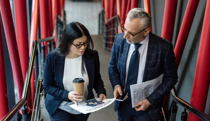 couple-discussing-news-over-newspaper-bdo