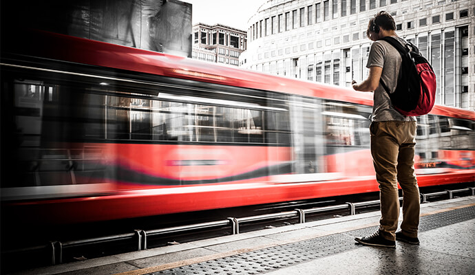 guy-with-headphones-in-front-of-passing-train-bdo